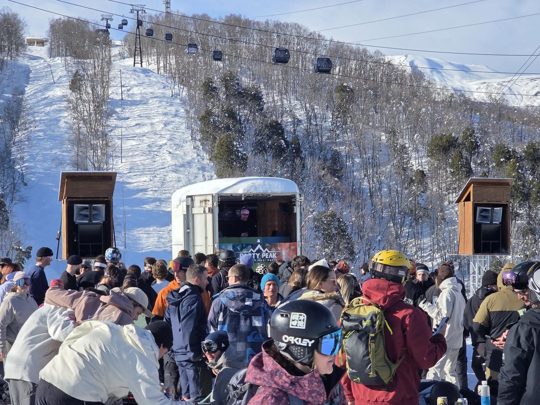 Gondola cabins and the lift line under a bluebird sky at Iwatake